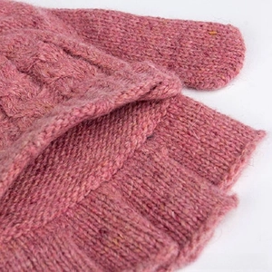 Gros plan détaillé de la texture en maille torsadée rose-violet et du revers de gant chaud