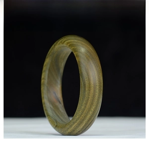 Primer plano de brazalete de sándalo verde con patrones naturales de vetas de madera