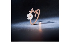 Detail of rose gold flower ring with shell petals and white zirconia leaf accents