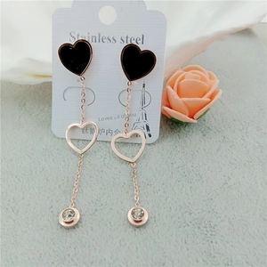 Détail de boucles d'oreilles cœur à pampilles en acier inoxydable or rose et zircon