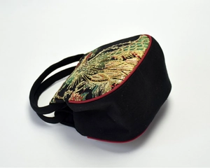 Close-up of intricate phoenix embroidery with gold and green sequins on a black handbag