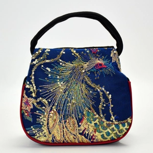 Ethnic peacock embroidery mini handbag with blue fabric and golden sequins on white background