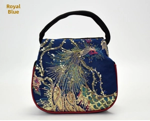 Detail of royal blue ethnic handbag with peacock embroidery and golden sequins