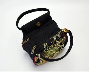 Top view of black ethnic embroidered handbag with golden sequins and two zip pockets