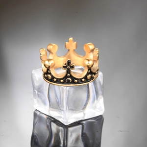 Macro shot of vintage golden crown ring with black cross details on ice background