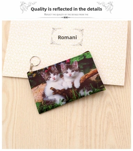 Detailed close-up of a zippered cat coin purse with metal keychain and printed kitten design