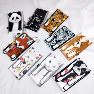 Flat lay of multiple animal-print silk scarves featuring panda, cat, and fox illustrations