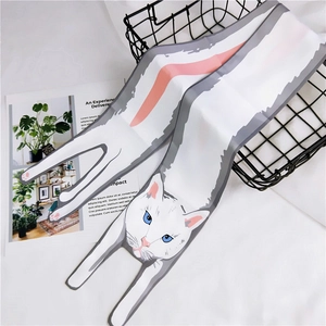 Detail of cartoon cat pattern silk scarf with pink ears on white fabric background