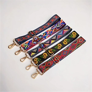 Vue détaillée de la sangle de sac large à motif ethnique coloré avec attaches et boucle dorées.