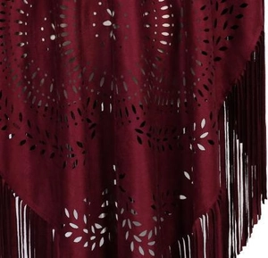 Close-up of laser-cut patterns and long tassels on dark red faux suede cape top