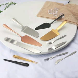 Flat lay of elegant stainless steel cake servers and forks in gold and silver finishes