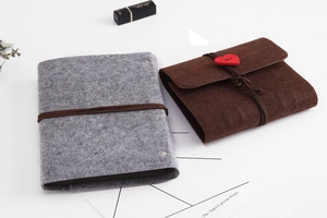 Detail of felt DIY photo albums in grey and brown with red heart button closure