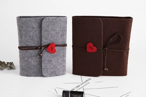 Detail of grey and dark brown felt DIY scrapbooks with elegant cord and heart charms