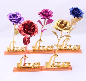 Detail of five colorful gold foil roses in purple and gold with a Love base