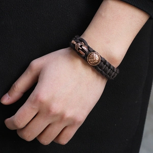 Brown braided survival bracelet with bronze Spartan helmet and shield charms on wrist