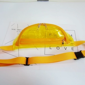 Macro view of yellow transparent PVC waist bag showing zippers and adjustable strap