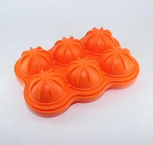 Detail of orange silicone mold with 6 spherical cavities and pumpkin textured patterns
