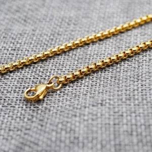Macro view of gold stainless steel popcorn chain link and lobster clasp detail