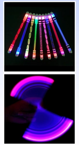 Close-up of LED glowing spinning pen with colorful light trails for finger play