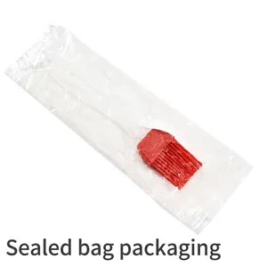 Silicone oil brush with red bristles and transparent handle in clear protective bag