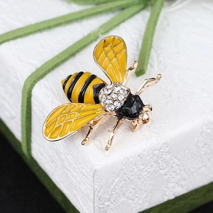 Detailed macro shot of yellow enamel bee brooch with rhinestones on a gift box