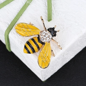 Detail shot of a bee brooch with gold plating, yellow stripes and sparkling rhinestones