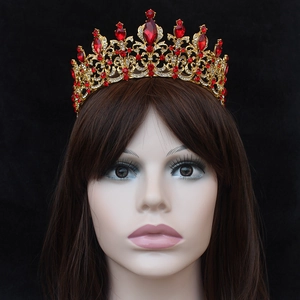Detailed close-up of Baroque gold bridal crown with red gems and sparkling rhinestones