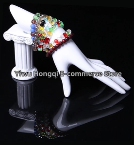 Close-up of colorful beaded bracelets layered on a white resin hand display stand