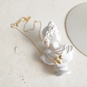 Detail of 925 sterling silver bee necklace with white zircon on a plaster bust