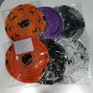 Flat-lay detail of folded Halloween paper lanterns with spider and bat prints in packaging