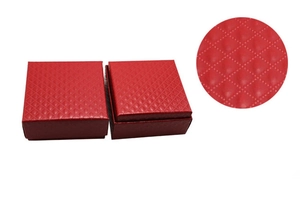Macro view of red gift boxes featuring a diamond quilted texture for jewelry storage