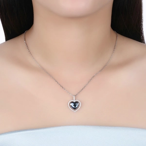 Detail of blue heart crystal necklace on model showing sparkling silver pavé stones