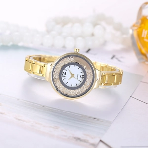 Detail of luxury gold quartz watch with diamond bezel and metal strap on magazine background