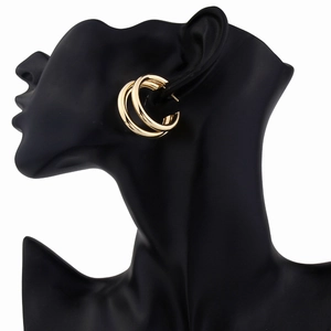 Detail of gold double hoop earrings with a high-polished mirror finish on a black model