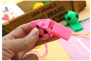 Detailed view of colorful soccer-shaped plastic whistles with matching lanyards