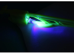 Detailed macro view of a yellow LED catapult airplane toy with glowing blue-purple light