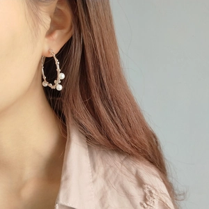Close-up of elegant 925 silver branch earrings with white shell pearls worn by a model