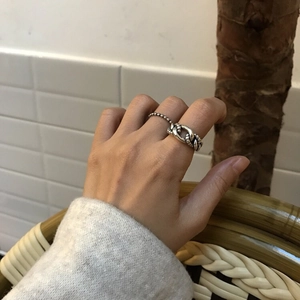 Detail view of vintage 925 sterling silver chain and beaded rings worn by a model