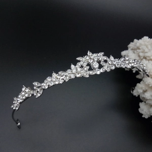 Close-up of silver bridal crown featuring intricate floral patterns and sparkling crystals