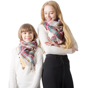 Detail of red and green plaid scarf in adults and kids sizes with soft boucle yarn texture