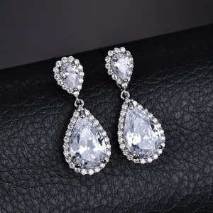 Eleganti orecchini pendenti in argento con zirconi cubici su sfondo in pelle nera