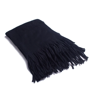 Close-up of pure black knit scarf showing fine texture and dense tassel edge detail
