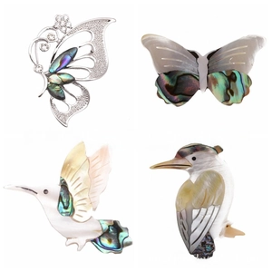 Detail of four bird and butterfly brooches featuring iridescent abalone shell inlays