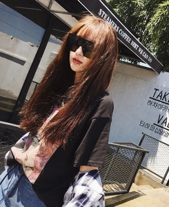 Street style shot featuring oversized square black sunglasses and a graphic portrait t-shirt