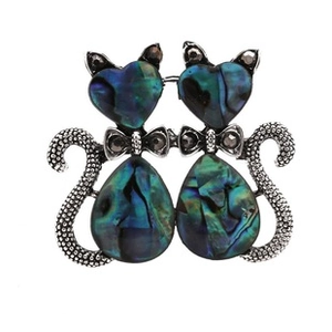 Close-up of cat brooch with iridescent blue and green abalone shell inlay on silver metal