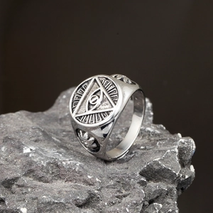 Detailed macro view of retro stainless steel eye ring on a textured grey rock surface