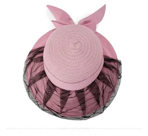 Top view of pink woven straw sun hat with black mesh lace veil and large bow detail