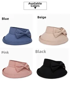 Detail view of foldable sun hats with bow and metal logo in blue, beige, pink, and black
