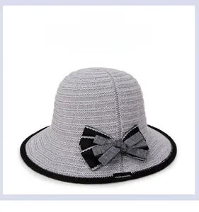 Close-up of gray hollow knit sun hat featuring a striped bow and black contrast edge