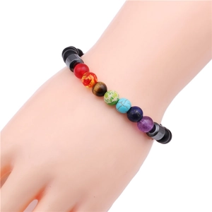 Detailed view of a multi-color natural stone bead bracelet worn on a female wrist